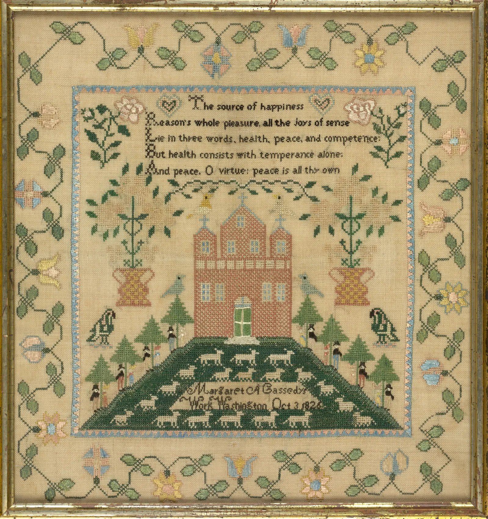 A framed 1826 needlework sampler with a stitched verse, a brick building flanked by potted trees, birds and a hillside of grazing sheep, signed in stitched lettering at the bottom: Margaret A Cassedy, Work, Washington, Oct 3 1826