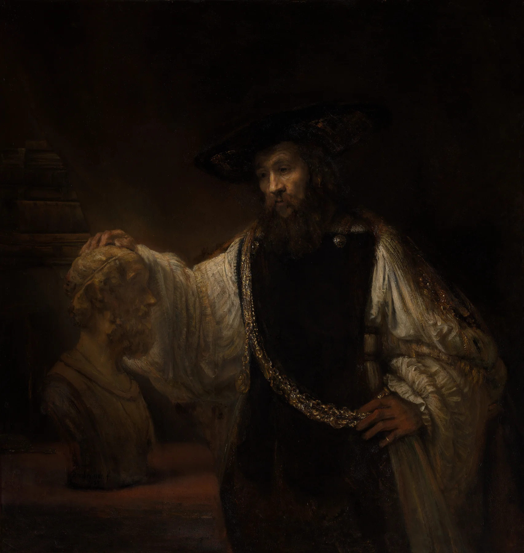 Rembrandt's 1653 oil painting Aristotle with a Bust of Homer, showing a bearded man in a broad-brimmed hat and gold chain resting one hand on the head of a marble bust while the other rests on his hip, against a dark interior background